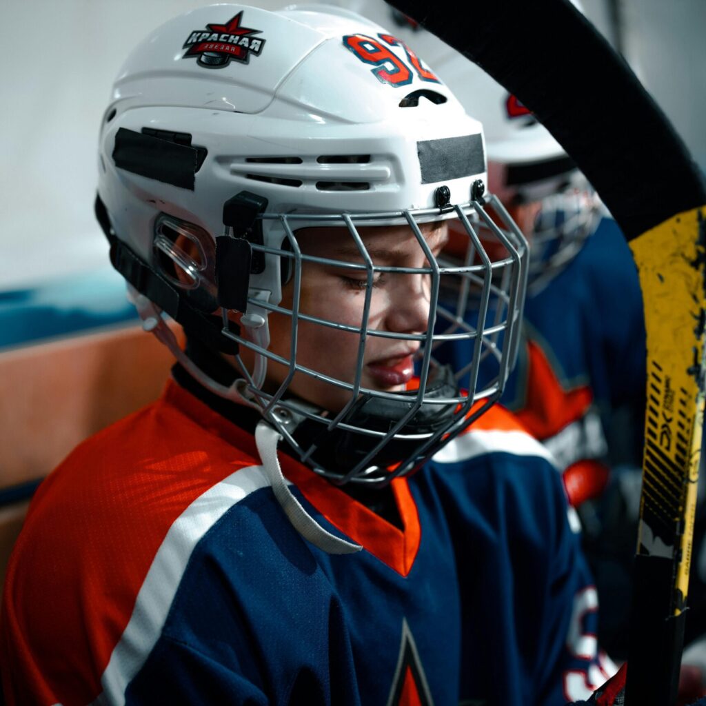 Close-up of a young ice hockey player in full gear, focused and ready for the game.